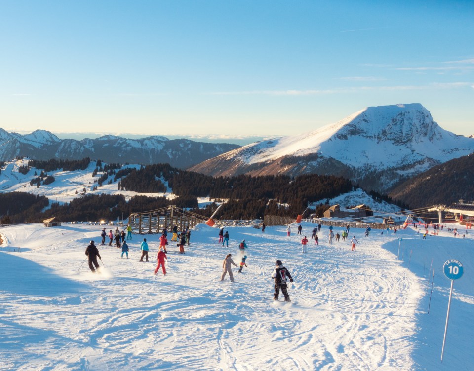 Лыжники и сноубордисты на солнечной синей трапезе в лыжной зоне Avoriaz/Morzine.